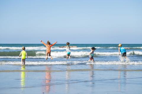 Kids jumping in waves at beach