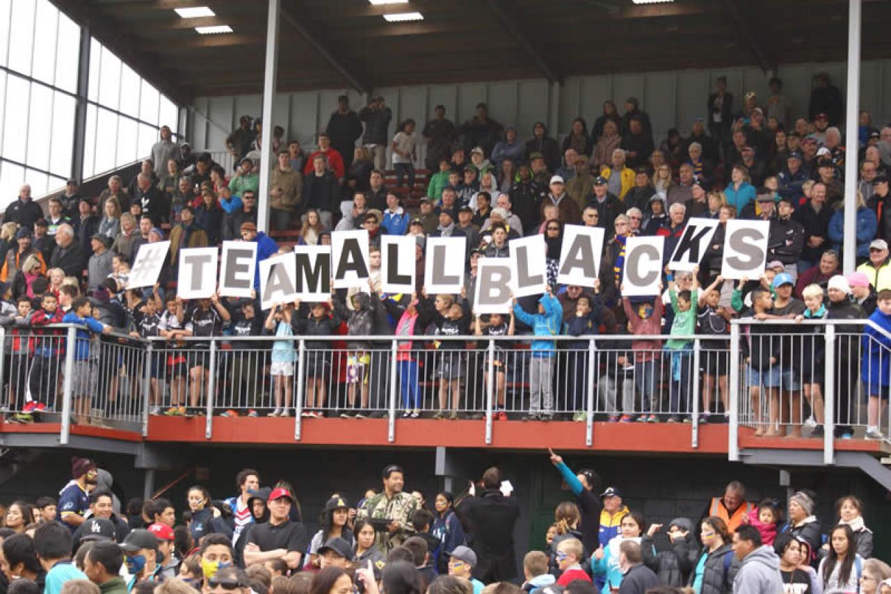 Crowd holding up team all blacks sign