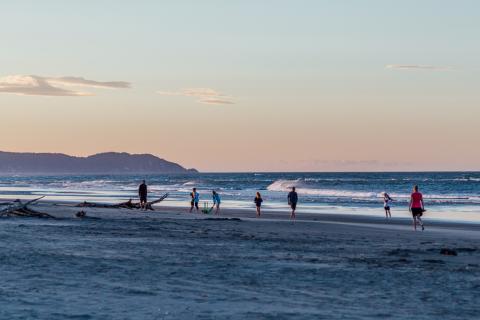 Family playing cricket on beach